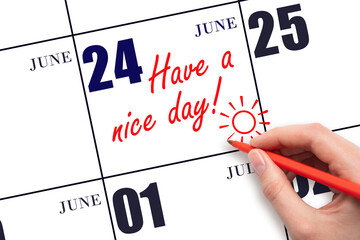 The hand writing the text Have a nice day and drawing the sun on the calendar date June 24