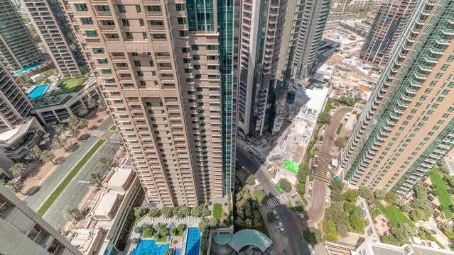 Aerial cityscape timelapse with modern architecture of Dubai downtown. Look down view to tall skyscrapers and towers with shadows moving fast. New construction site.