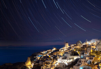 Astrolandscape of star trails over Oia village. Santorini Island. Cyclades of Greece.
