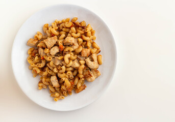 Pasta with meat and tomatoes on a white plate on a light background. Top view.