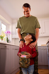 American Army Mother In Uniform Home On Leave With Son Holding Her Cap In Family Kitchen