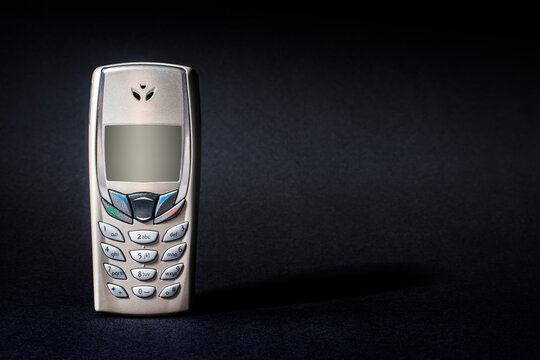 Old Silver and Gold Phone with buttons on black background. - Powered by Adobe