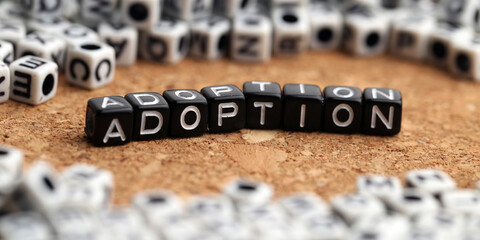 Adoption, Closeup of word on plastic cube on wooden desk background concept