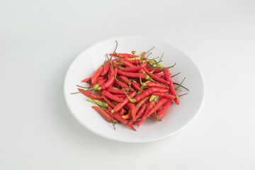 group of fresh red chilies or Cabai Rawit on white plat isolated on white background