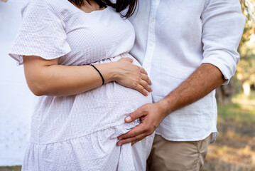 Pregnant woman and her husband touching the tummy