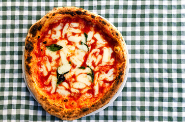 Margherita pizza is a traditional Italian dish. Sauce, mozzarella and basil are ingredients that create a unique taste. The concept of Italian street food. Top view. Copy space.