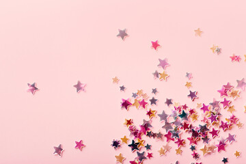 Pink and yellow pastel Stars Glitter Confetti on pink background. Festive backdrop