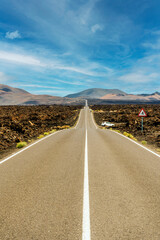 Road in volcanic arid landscape of Timanfaya National Park, Lanzarote, Canary Islands, Spain
