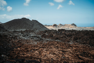 Arid volcanic landscape with lava fields in Timanfaya National Park, Lanzarote, Canary Island, Spain