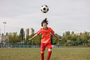 A girl soccer player heading the ball