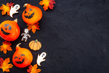 Frame of orange Halloween pumpkins and funny cookies, top view