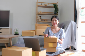 SME entrepreneur Small business entrepreneurs Online selling ideas,Happy Young Asian business owner work on computer and a boxs at home,delivery SME procurement package box deliver to customers,