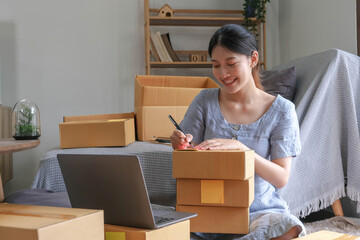 SME entrepreneur Small business entrepreneurs Online selling ideas,Happy Young Asian business owner work on computer and a boxs at home,delivery SME procurement package box deliver to customers,