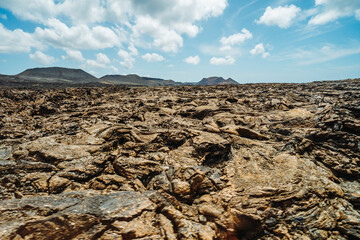 Fototapeta na wymiar Arid volcanic landscape with lava fields in Timanfaya National Park, Lanzarote, Canary Island, Spain