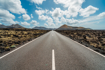 Road in volcanic arid landscape of Timanfaya National Park, Lanzarote, Canary Islands, Spain