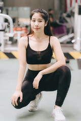 Naklejka na ściany i meble Asian female fitness athlete in gym