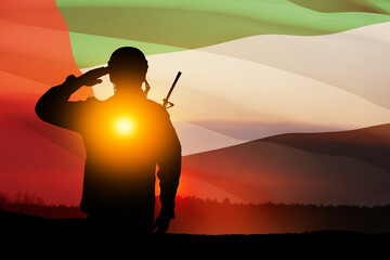 Silhouette of soldier saluting on background of UAE flag and the sunset or the sunrise. Commemoration Day.