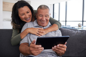 Senior couple use mobile tablet technology, video call family and communicate with friends on sofa...