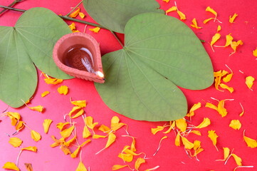 Indian Festival Dussehra, showing golden leaf and flowers with traditional diya on red background....