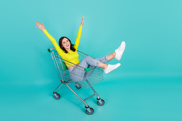 Full size photo of cool brunette hair young lady ride trolley wear top jeans shoes isolated on teal...