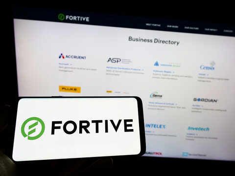 Stuttgart, Germany - 09-25-2022: Person holding mobile phone with logo of American technology company Fortive Corporation on screen in front of web page. Focus on phone display.
