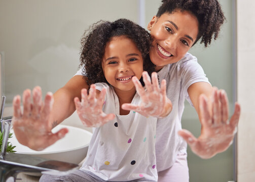 Woman, child and washing hands in bathroom, cleaning to prevent germs and virus in home. Soap, water and hygiene, girl and mom from Brazil. Teaching, learning a clean morning routine and happy family