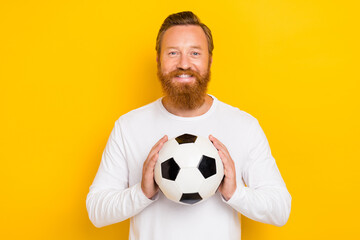 Photo of satisfied glad person arms hold football toothy smile isolated on yellow color background