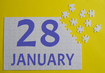 28 january calendar date on a white puzzle with separate details. Puzzle on a yellow background with a blue inscription