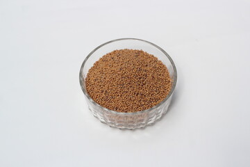 Mustard seeds on a glass bowl, mustard seeds on white background