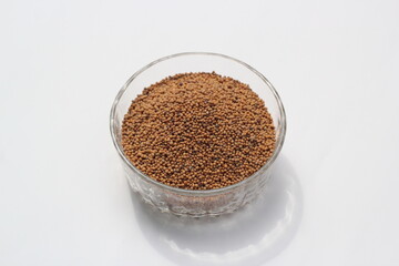 Mustard seeds on a glass bowl, mustard seeds on white background
