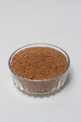 Mustard seeds on a glass bowl, mustard seeds on white background
