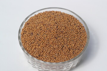 Mustard seeds on a glass bowl, mustard seeds on white background