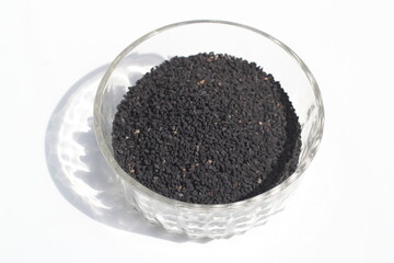 Black cumin seeds on a white background, black cumin seeds on a bowl