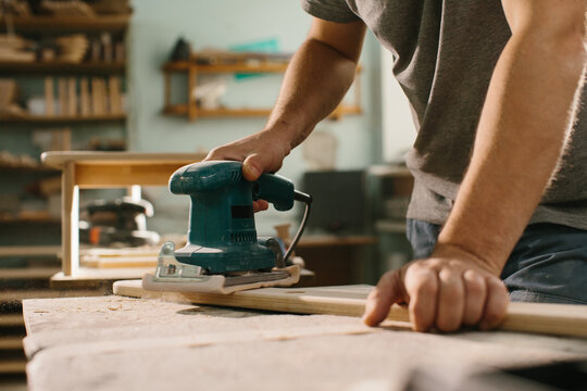 Grinding machine makes wooden polishing of bar plank.