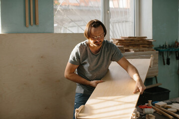 Obraz premium A carpenter makes a Montessori climbing set for children in his workshop.