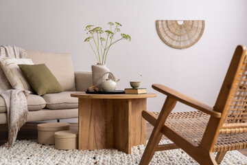 Warm and cozy interior of living room with beige sofa, pillow, wooden coffee table, decoration,...