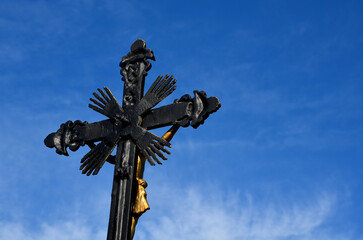 Repairing God's tortures in the countryside. the metal cross is painted and gilded. the...