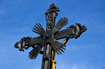 Repairing God's tortures in the countryside. the metal cross is painted and gilded. the...
