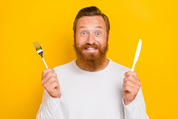 Photo of attractive young guy wait restaurant waiter hold fork plastic knife dressed trendy white...