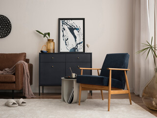 Elegant interior with mock up poster frame, blue armchair, commode, brown sofa, carpet, decoration, side table and personal accessories. Stylish home decor. Template.