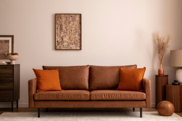 Warm and cozy interior of living room space with brown sofa, beige carpet, lamp, mock up poster...