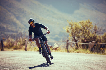 Obraz premium Mountain bike street, cycling exercise and man training for professional competition, happy with sports on bicycle and freedom on the road for sport. Biker athlete riding in nature for adventure