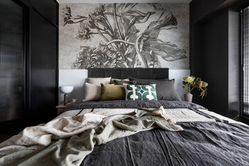 Interior design of harmonized bedroom with beautiful wallpaper, modern bed, flowers in vase,...