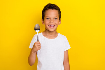 Portrait of cheerful person boy dressed stylish trendy clothes toothy smile arm hold spoon wait supper isolated on yellow color background