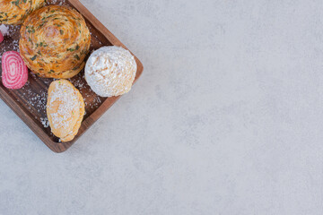 Fototapeta premium Bunch of various sweets on wooden board