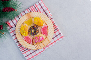 Christmas cookies, donut and marmalades on dark plate