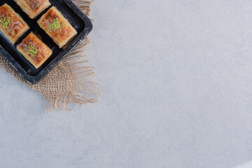Sweet baklava with pistachios on dark board