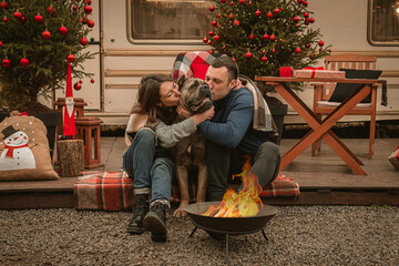 Happy couple in love and their dog spend time together on Christmas holidays. Cane Corso and his...