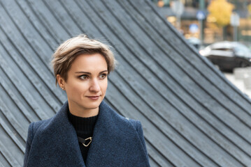 Portrait of an attractive short-haired blonde in the city in autumn