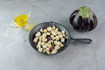 Sliced fresh eggplant vegetable with oil on a gray background
